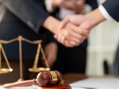 Dos personas estrechándose la mano en señal de acuerdo jurídico