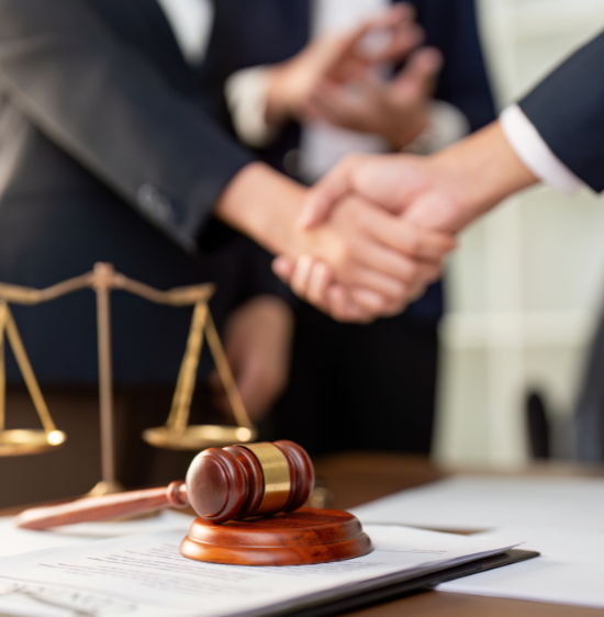 Dos personas estrechándose la mano en señal de acuerdo jurídico